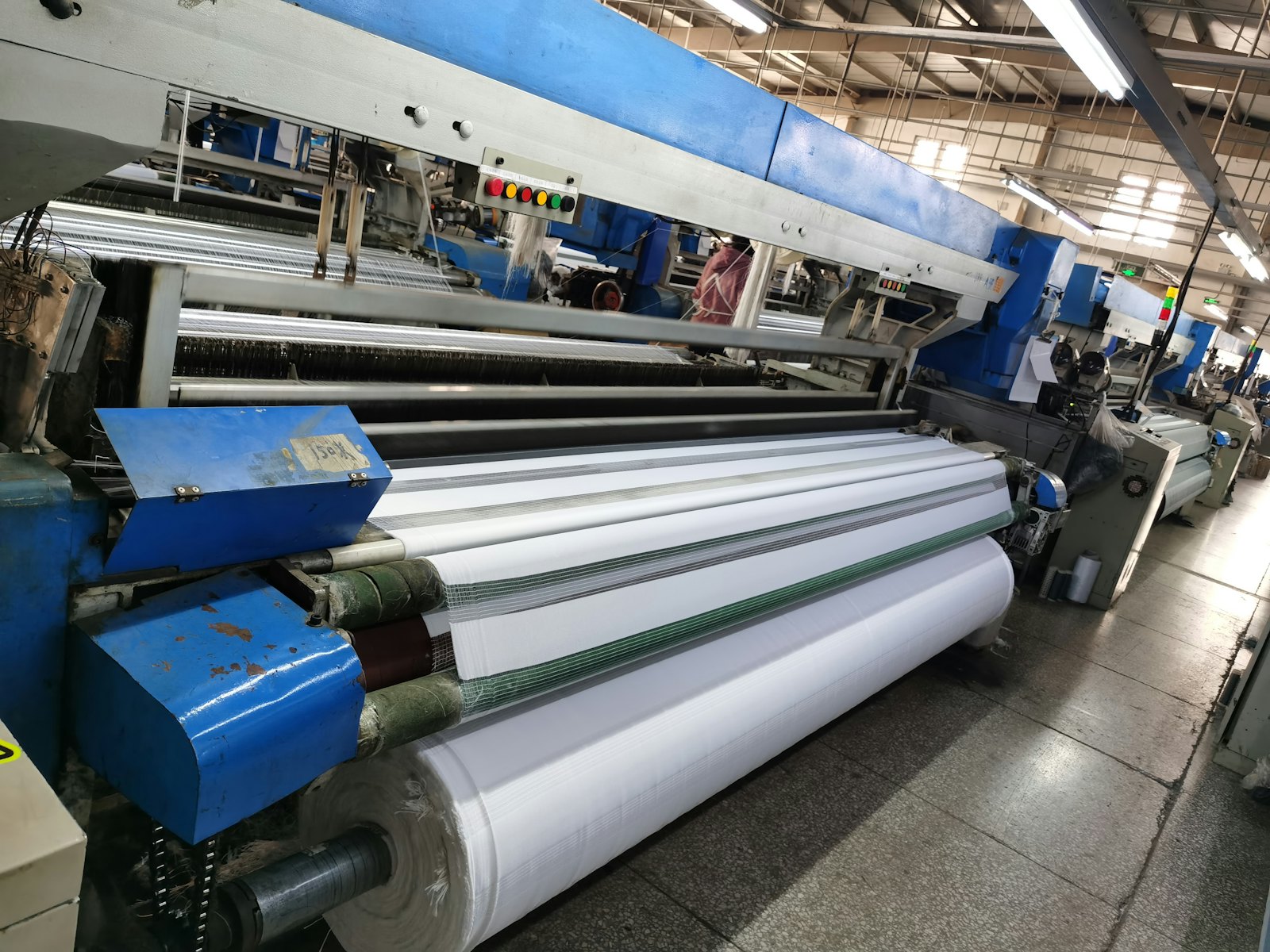 Sheet running through calender rollers on a production line